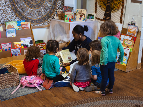 children reading with a teacher