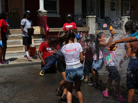 Children playing in water in city street
