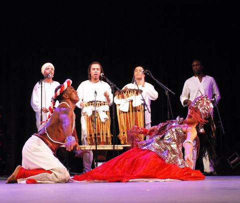 two dancers on stage with four musicians in the background