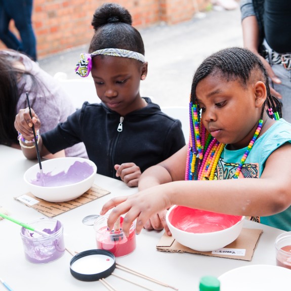 Two young girls painting bowls with the Clay Studio
